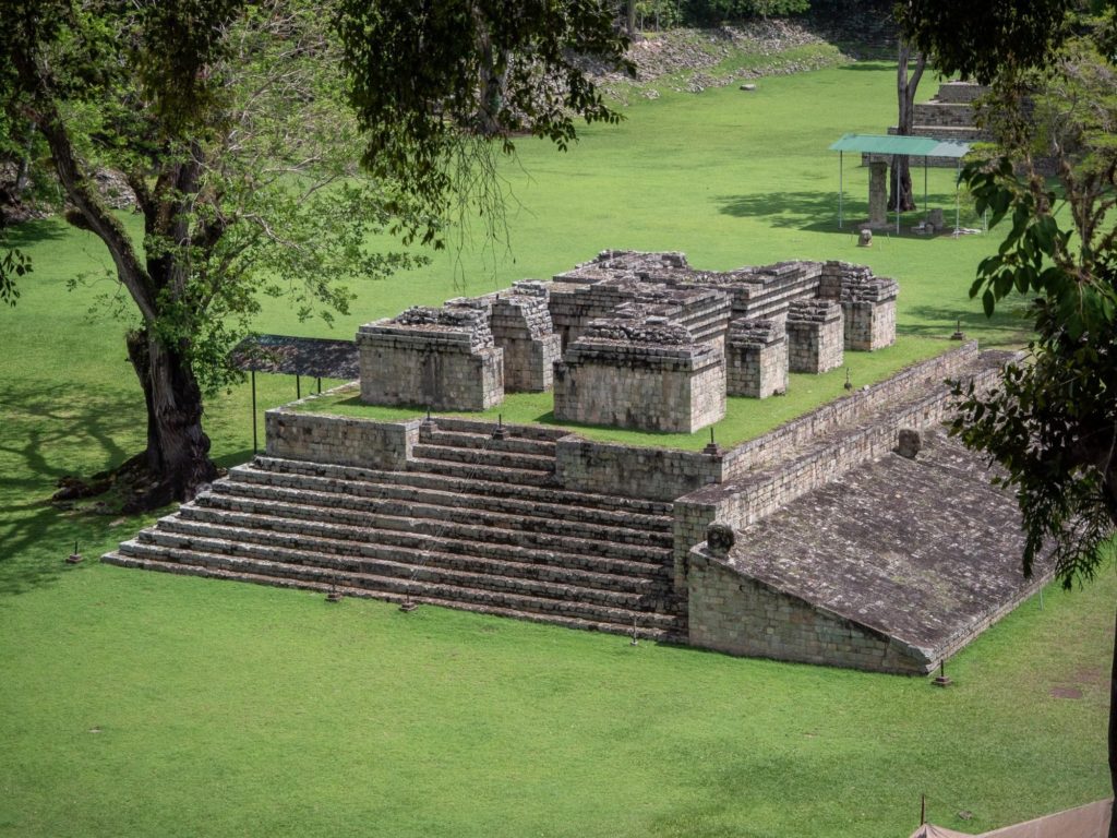 The remains of an old Mayan ball court can be seen from a high vantage point. The hoops have worn away over time but the sloped area still stands in one piece.
