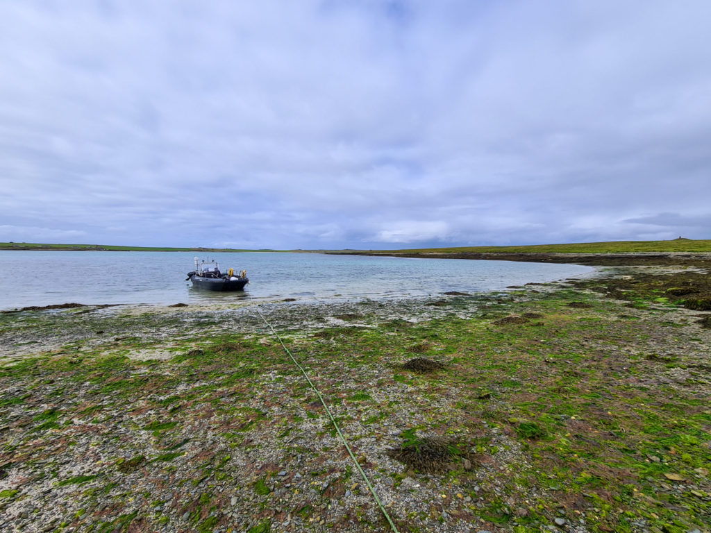A Rigid Inflatable Boat (RIB) anchored at a small island off Papa Westray.