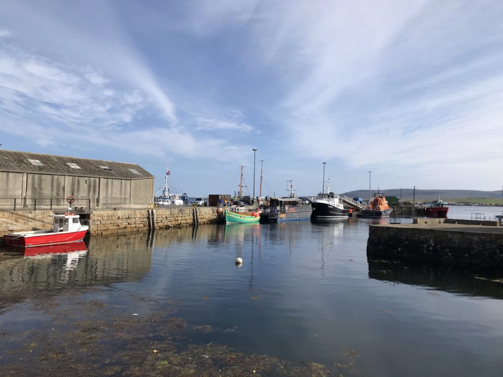 A few small colourful boats sit docked at Stromness.