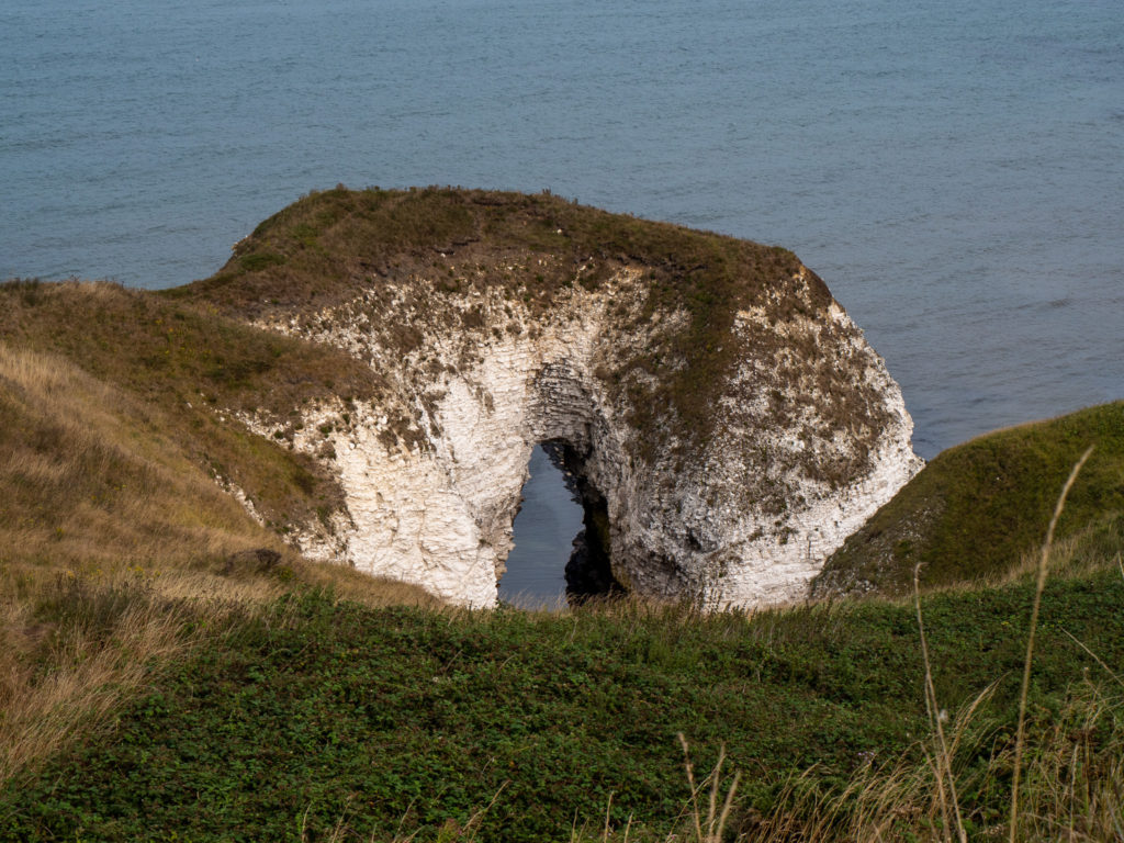 A sea arch of white stone.