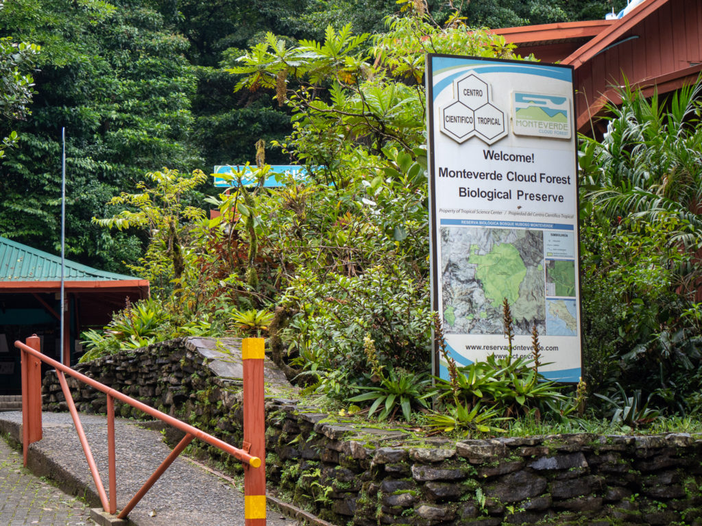 A large sign and a walkway welcomes visitors to the Monteverde cloud forest biological preserve.