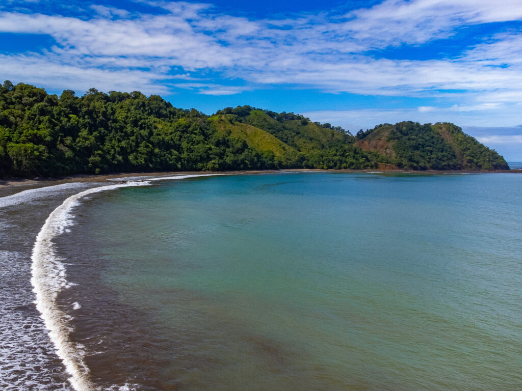 An elevated view of Herradura Beach, Costa Rica. Looking over the sea at a tropical coastline.