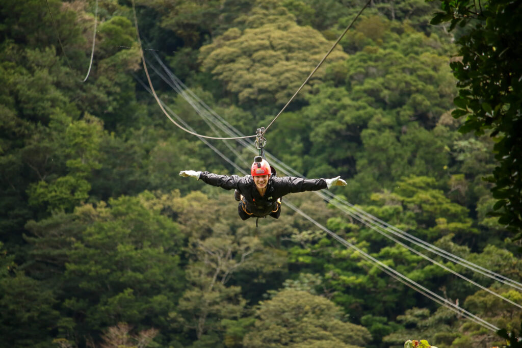 Dan ziplining in the 'superman' position on his front with his arms out.