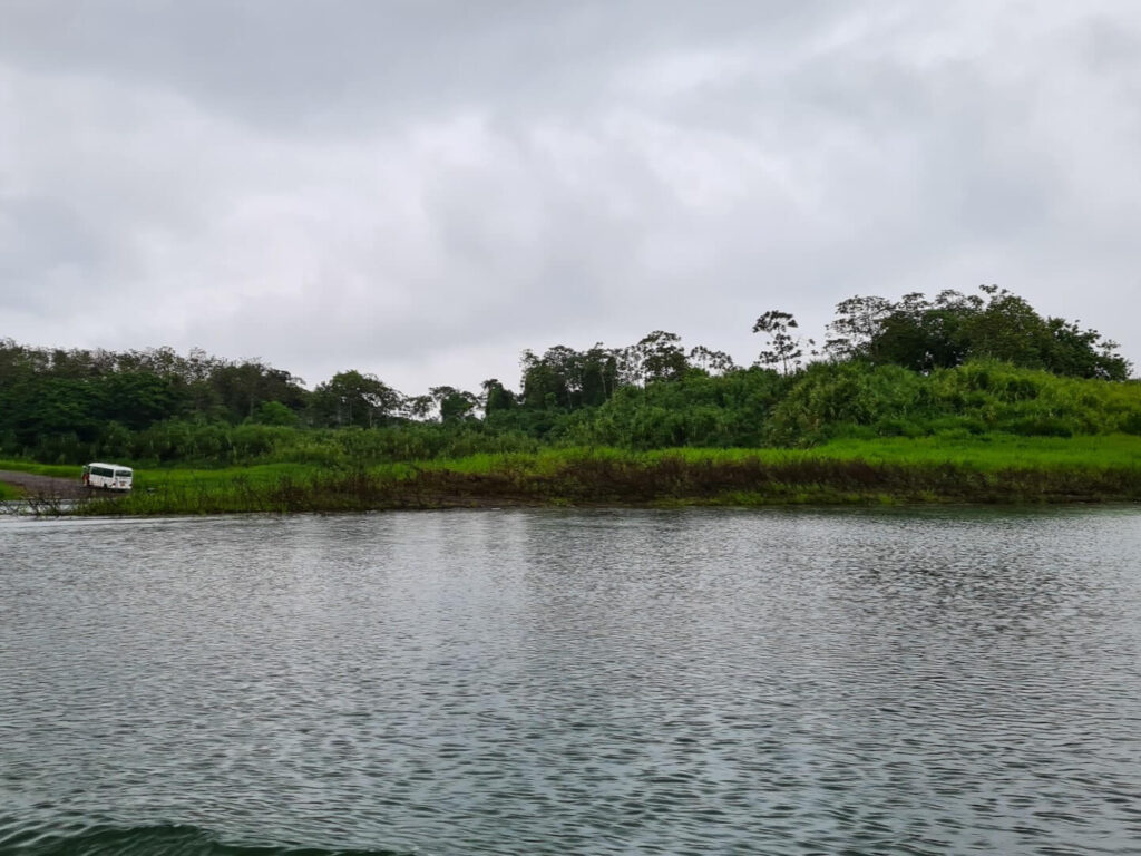 Taking a ferry across Lake Arenal. The ferry bus drives away in he distance.