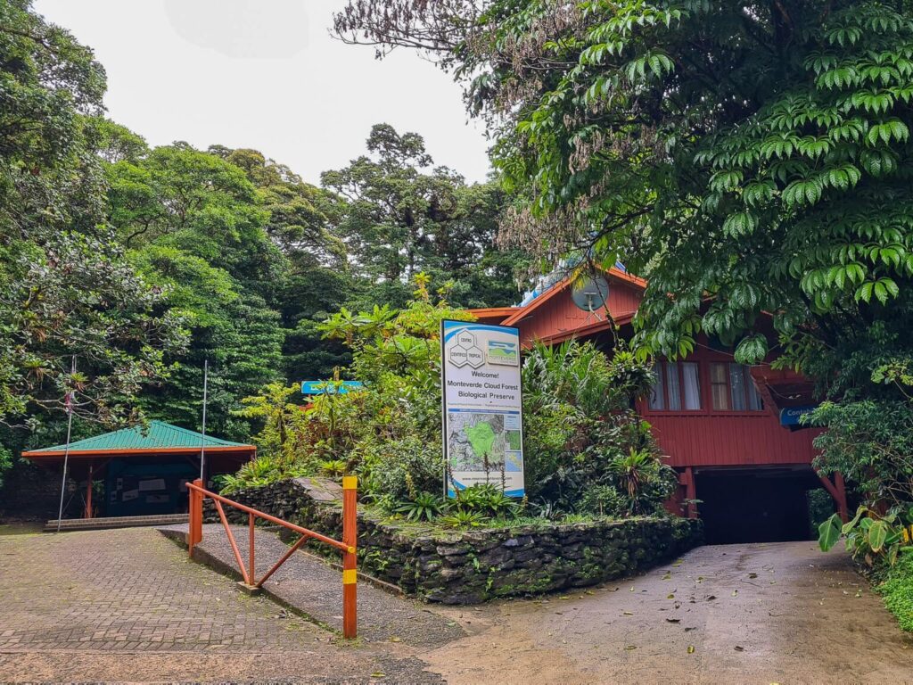 A large sign and a walkway welcomes visitors to the Monteverde cloud forest biological preserve.