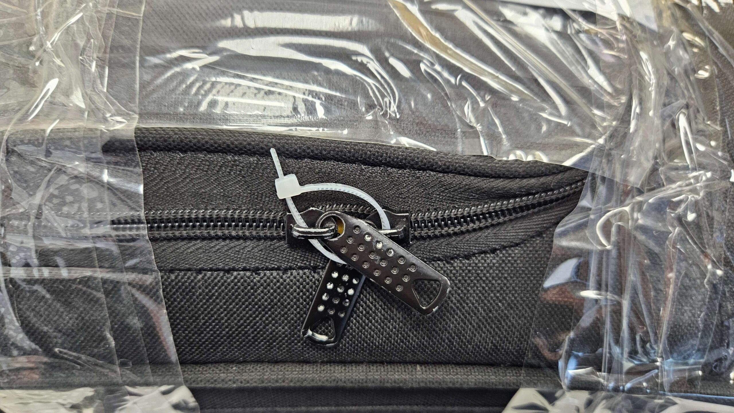 A zip-tie has been put through the zips on a suitcase. This is in accordance with Send My Bag's guidelines.