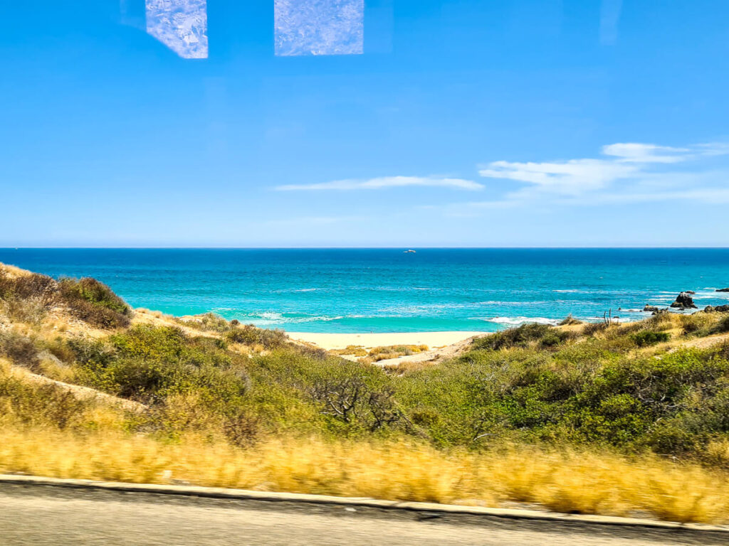 Driving along ta road by a beach.