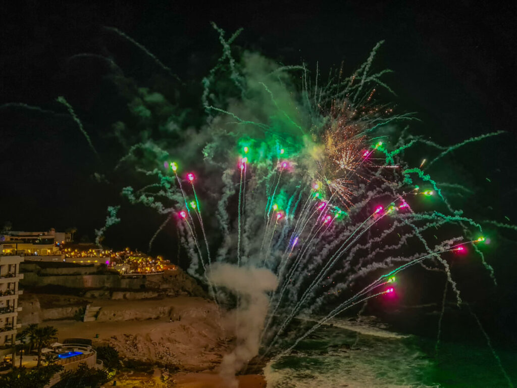 Bright fireworks of red and green erupt in the sky.