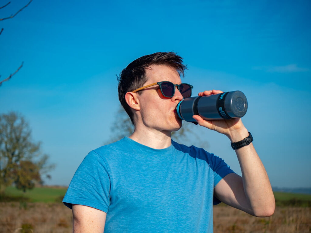 Dan taking a drink from his Water-to-Go water bottle while looking out at a cloudless sky.