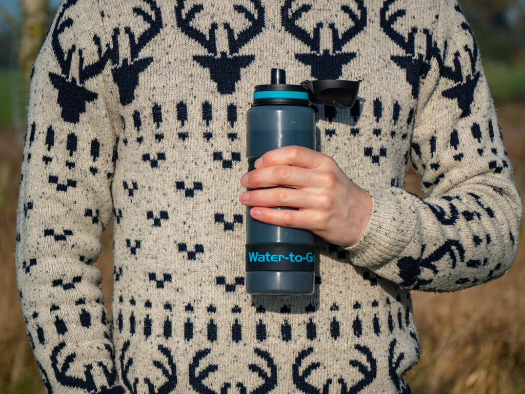 Dan holding a Water-to-Go reusable water bottle in his hand. The cap is open, ready for him to take a drink.