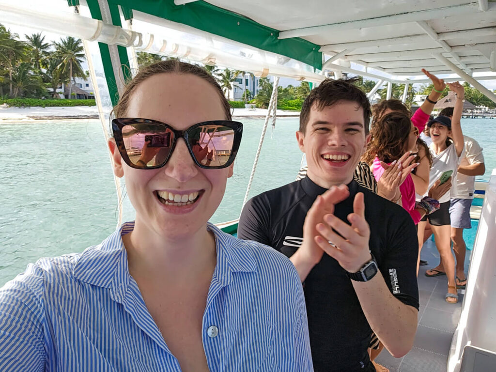 Lucy and Dan are dancing and clapping on a boat with a small group of tourists. They are all on a group trip with Ocean Tours Mexico.